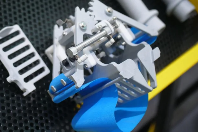Food-contact robotic gripper and handle in metal-detectable nylon on a display tray