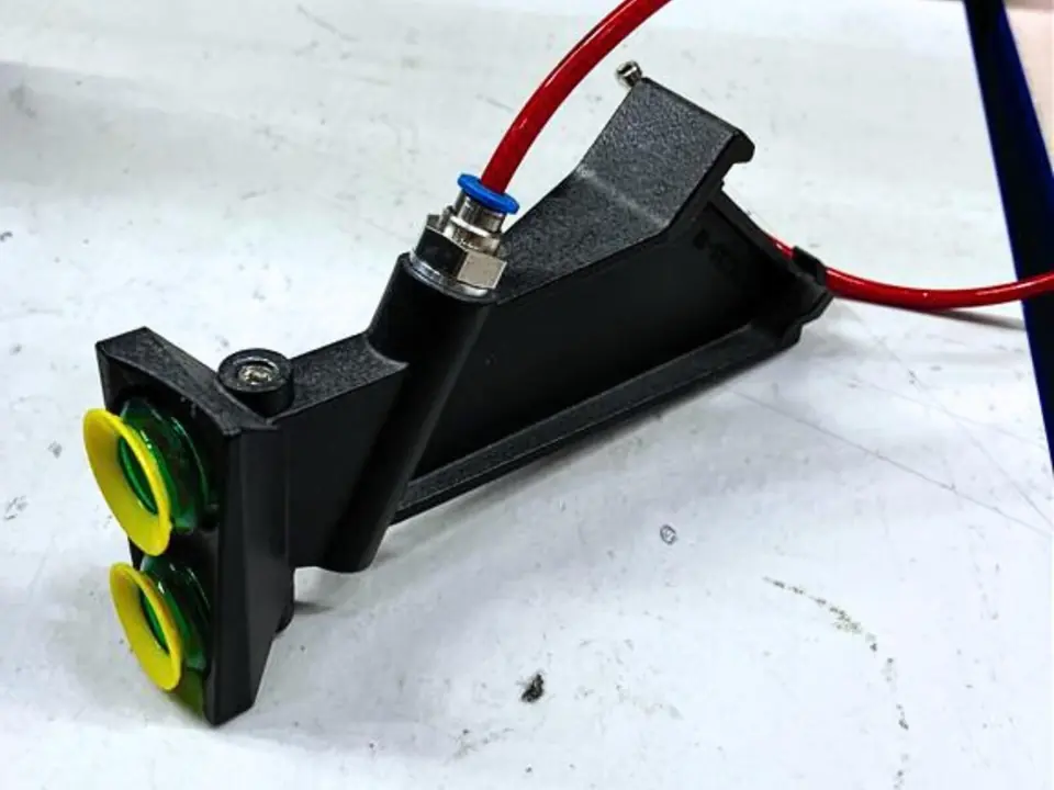 Black vapor-smoothed pick-and-place part fitted with suction cups and an air hose